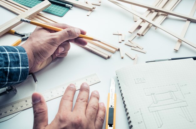 Male working on worktable with balsa wood material