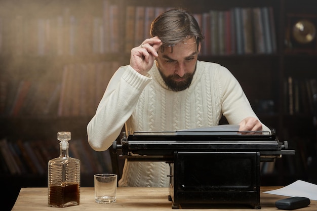 Photo a male writer rereads what is written on a typewriter