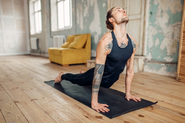 Мужская йога делает упражнения отжимания
