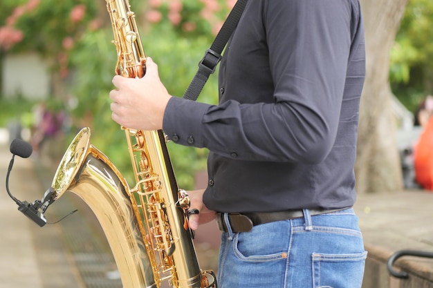 Male39s hands playing the saxophone outdoors