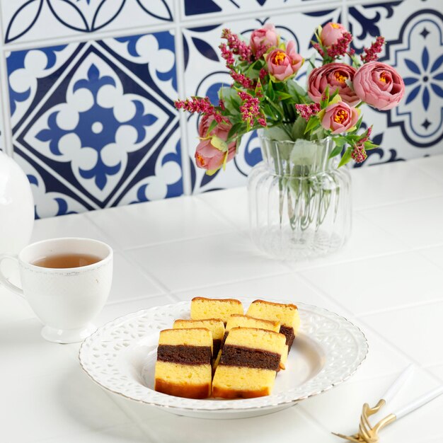 Maleisisch gerecht kek lapis sarawak of sarawak gelaagde taart op witte tafel geserveerd met thee
