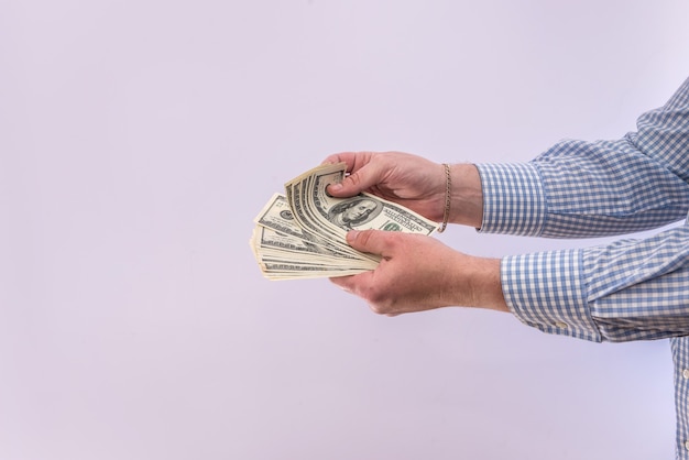 Males hand holds banknote of  100 dollar bills isolated. finance concept