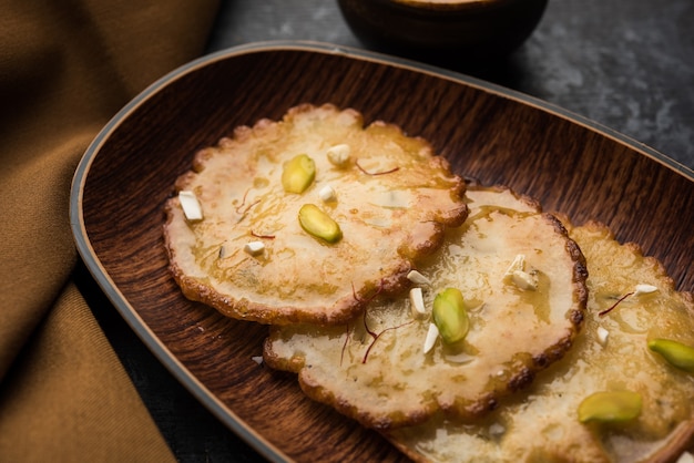 Malpua sweet - Traditional Indian dessert or pancake for festivals, served in plate with rabri or rabdi . selective focus