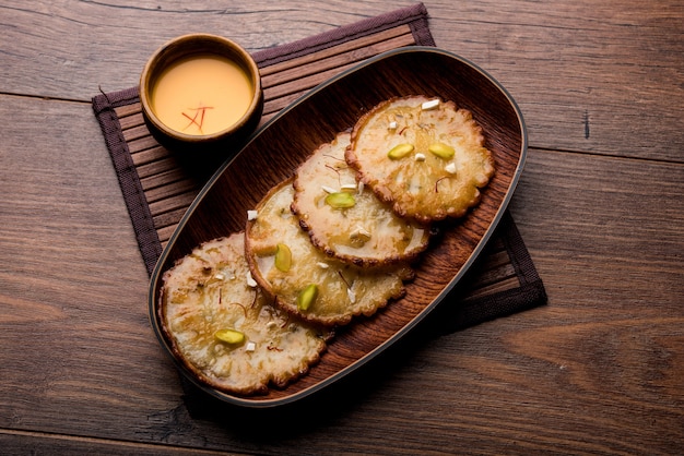 Malpua sweet - Traditional Indian dessert or pancake for festivals, served in plate with rabri or rabdi . selective focus