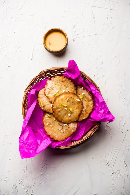 Malpua sweet - traditional indian dessert or pancake for festivals, served in plate with rabri or rabdi . selective focus