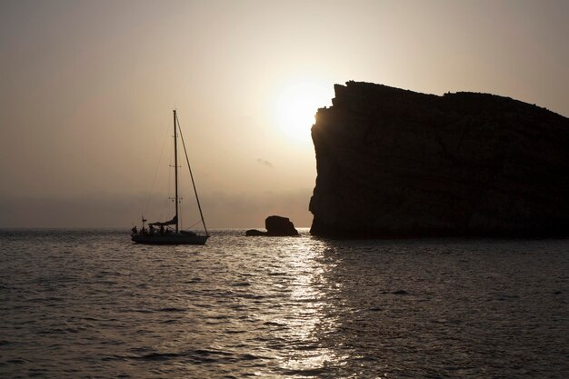 Malta, eiland Gozo, uitzicht op de rotsachtige kustlijn van het eiland in Dwejra en een zeilboot