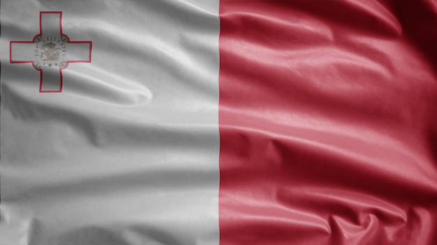 Photo maltese flag waving in the wind. close up of malta banner blowing soft silk. cloth fabric texture ensign background.