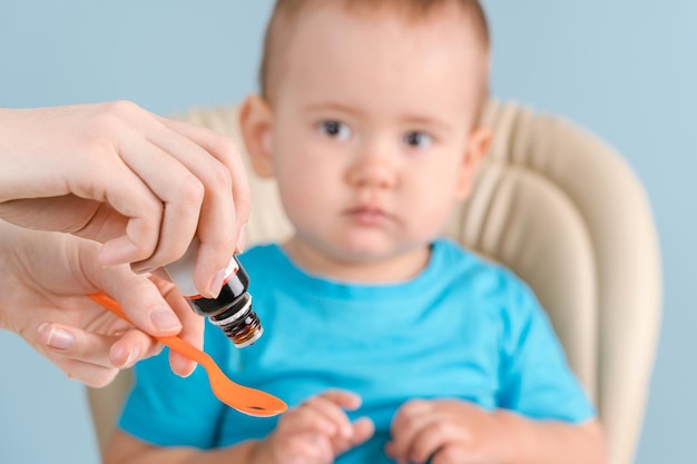 Mam geeft het pasgeboren medicijn op een lepel