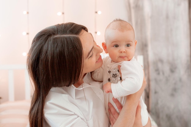 Mama houdt de baby thuis in de slaapkamer kusjes