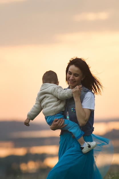 Mama knuffelt baby en bij zonsondergang buiten telefoto-opname