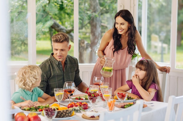 Mama lacht terwijl ze limonade inschenkt voor haar dochter