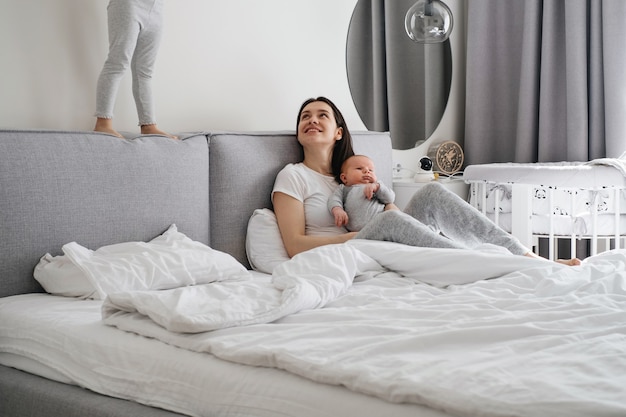 Mama met twee kinderen thuis in de slaapkamer