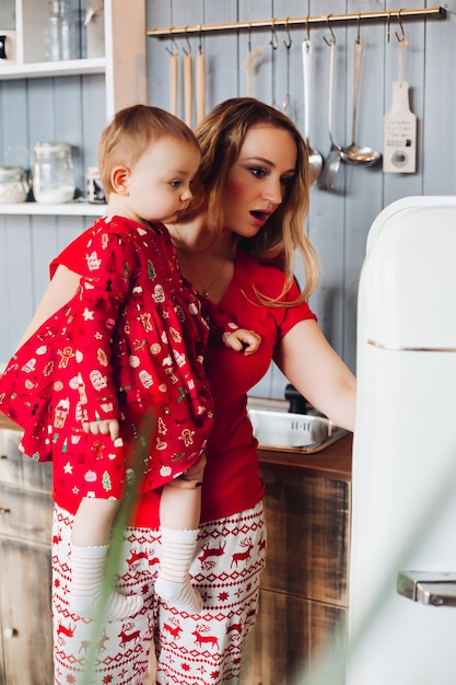 Mamma die met de hand weinig dochter houden, en binnen ijskast tonen kijken.