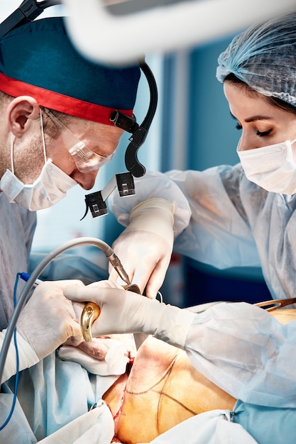 Mamoplasty, close-up artsen tijdens reconstructieve plastische chirurgie op de vrouwelijke borstklieren, ocologie van de vrouwelijke borst.