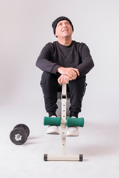 Man over 50 doing crunches on white background