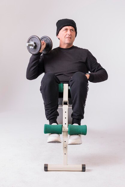 Man over 50 doing crunches on white background