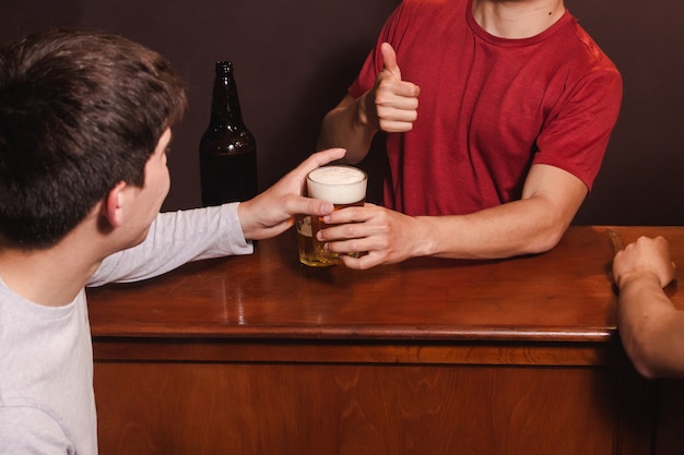 Man aan de bar bedankt zijn klant voor het kopen van bier.