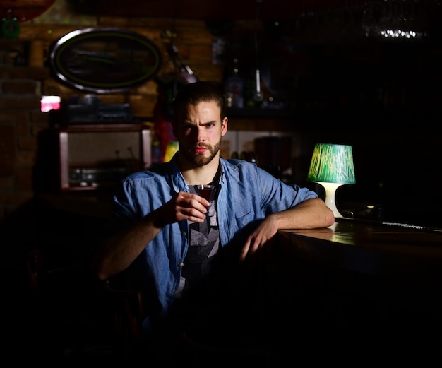 Man aan de bar drinkt een glas shot of likeur