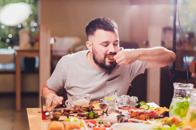 Man aan de grote tafel met eten.