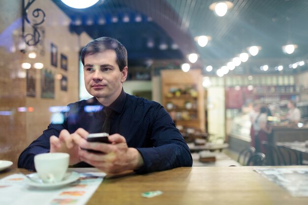 Man aan de tafel sms&#39;en