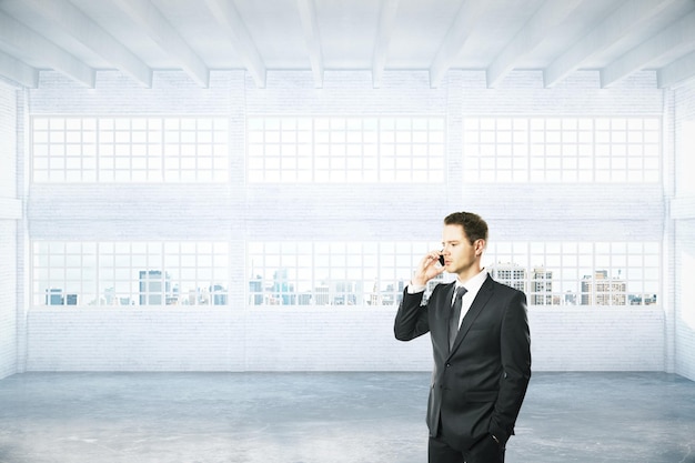 Man aan de telefoon in hangar