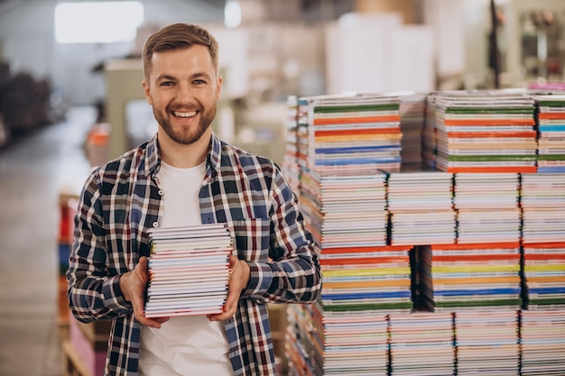 Man aan het werk in de drukkerij met papier en verf