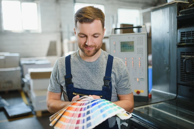 Foto man aan het werk in de drukkerij met papier en verf