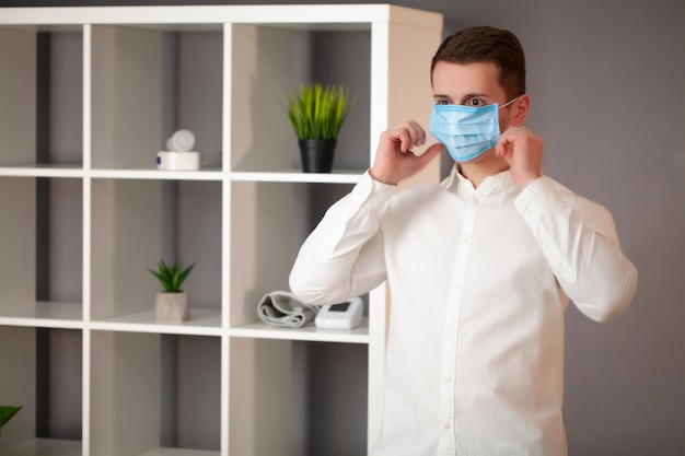 Man aan het werk in het kantoor dragen van een masker voor bescherming tegen coronavirus