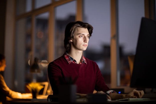 Man aan het werk in het kantoor 's nachts