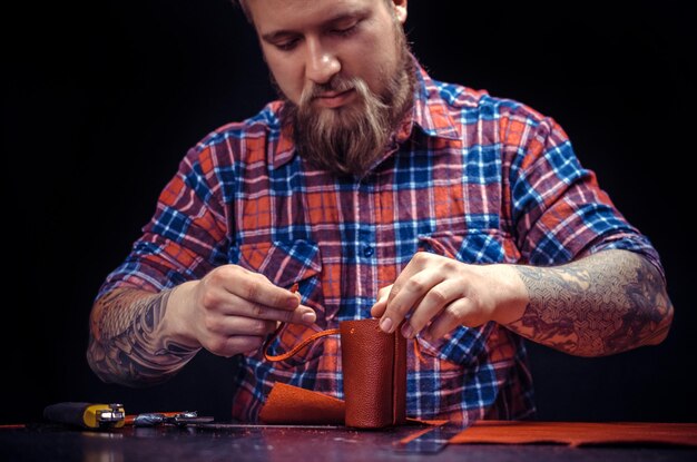 Man aan het werk met leer vormt nieuw leerproduct in zijn atelier