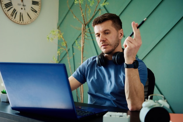 Man aan het werk op afstand op kantoor aan huis met laptop