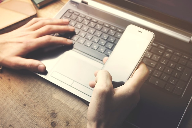 Man aan het werk op een laptop op een houten tafel