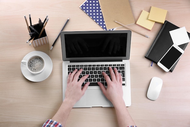 Man aan het werk op laptop aan tafel