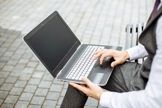 Man aan het werk op laptop in het park op een zonnige dag