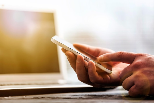 Man aan het werk vanuit huis met behulp van slimme telefoon