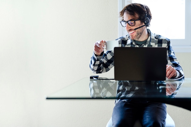 Foto man aan het werk vanuit huis op een laptopcomputer die aan een bureau zit te surfen op internet