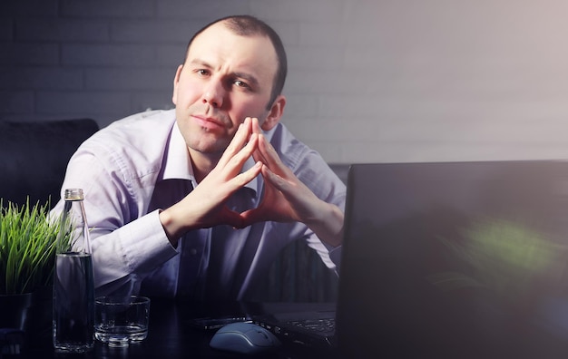 Man aan tafel en bezig met laptop