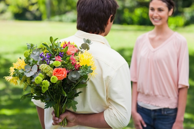 Photo man about to present a bouquet of flowers to his friend