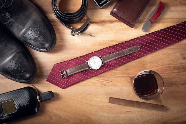 Man accessories with whiskey and cigar on table