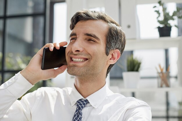 Man accountant of bedrijfsadvocaat praten op smartphone met financiën papierwerk op werkplek