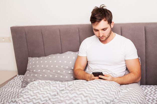 Man addicted to his mobile phone in bed