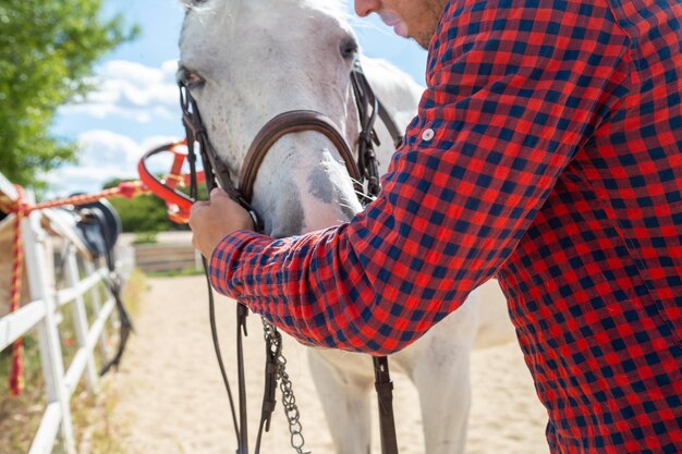 写真 牧場で馬の<unk>を調整する男