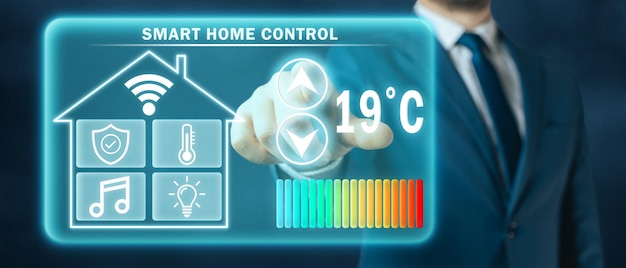 スマート ホーム コントローラーの暗い背景の仮想画面で加熱温度を調整する男