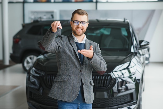 Man adult customer male buyer client wears classic suit white\
shirt chooses auto wants to buy new automobile touch check car in\
showroom vehicle salon dealership store motor show indoor sales\
concept