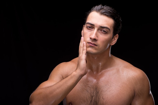 Man after taking shower on dark background