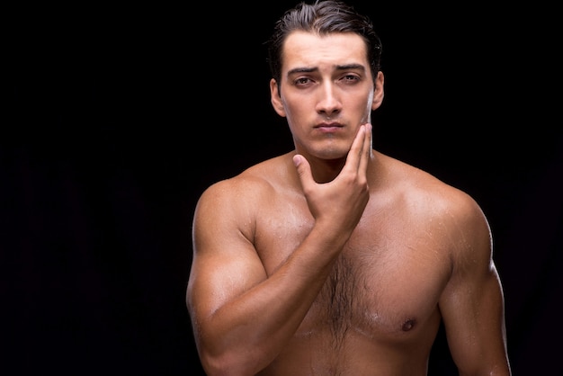 Man after taking shower on dark background