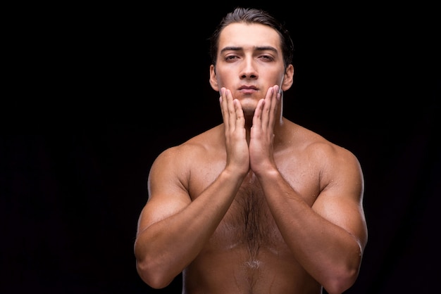 Man after taking shower on dark background