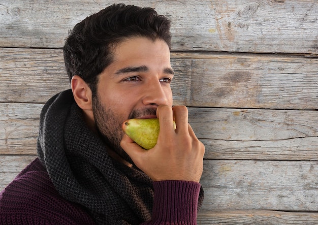 Man against wood with pear and scarf