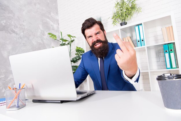 Man agressieve regisseur werkt online laptop modern kantoor haat en minachting concept