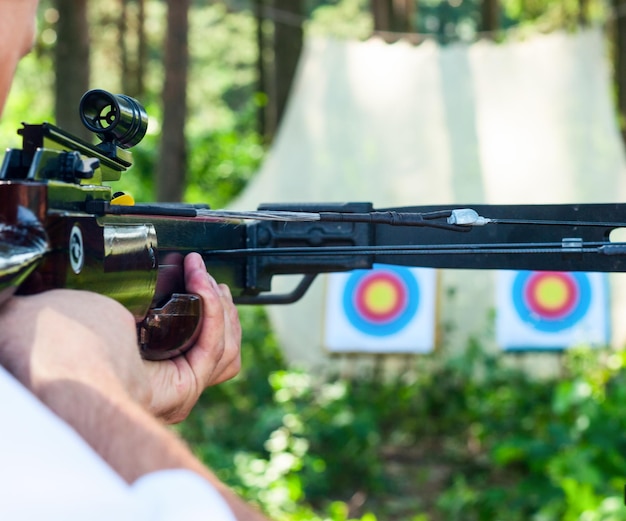 Photo man aiming crossbow at target